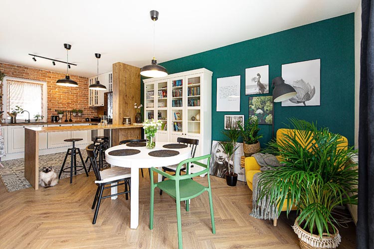 salon z aneksem kuchennym ze ścianą z cegły i ścianą pomalowaną na kolor zielony