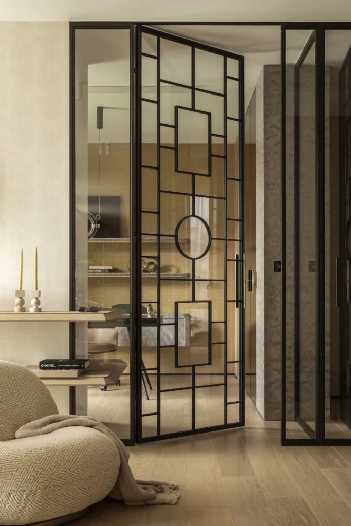 Szklane drzwi loftowe z metalowym detalem i ażurem – detal wykończenia wnętrza w apartamencie na Powiślu.