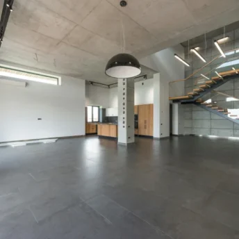Industrialny loft, w którym wykorzystano beton architektoniczny na ścianach, suficie i podłodze