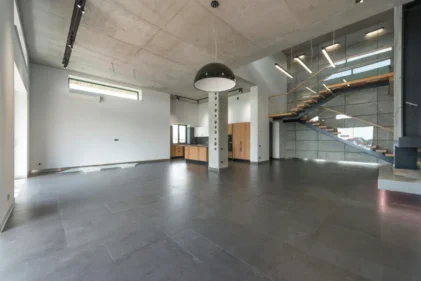 Industrialny loft, w którym wykorzystano beton architektoniczny na ścianach, suficie i podłodze