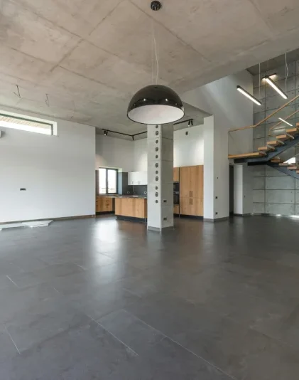 Industrialny loft, w którym wykorzystano beton architektoniczny na ścianach, suficie i podłodze