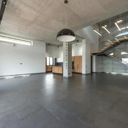 Industrialny loft, w którym wykorzystano beton architektoniczny na ścianach, suficie i podłodze