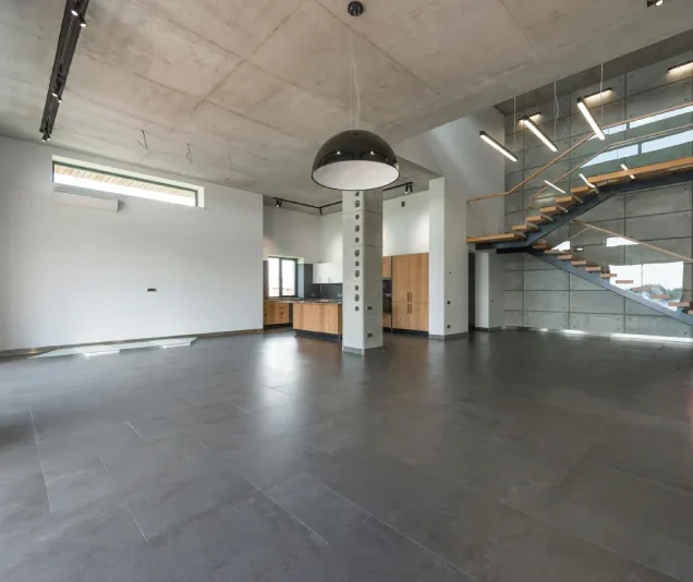 Industrialny loft, w którym wykorzystano beton architektoniczny na ścianach, suficie i podłodze
